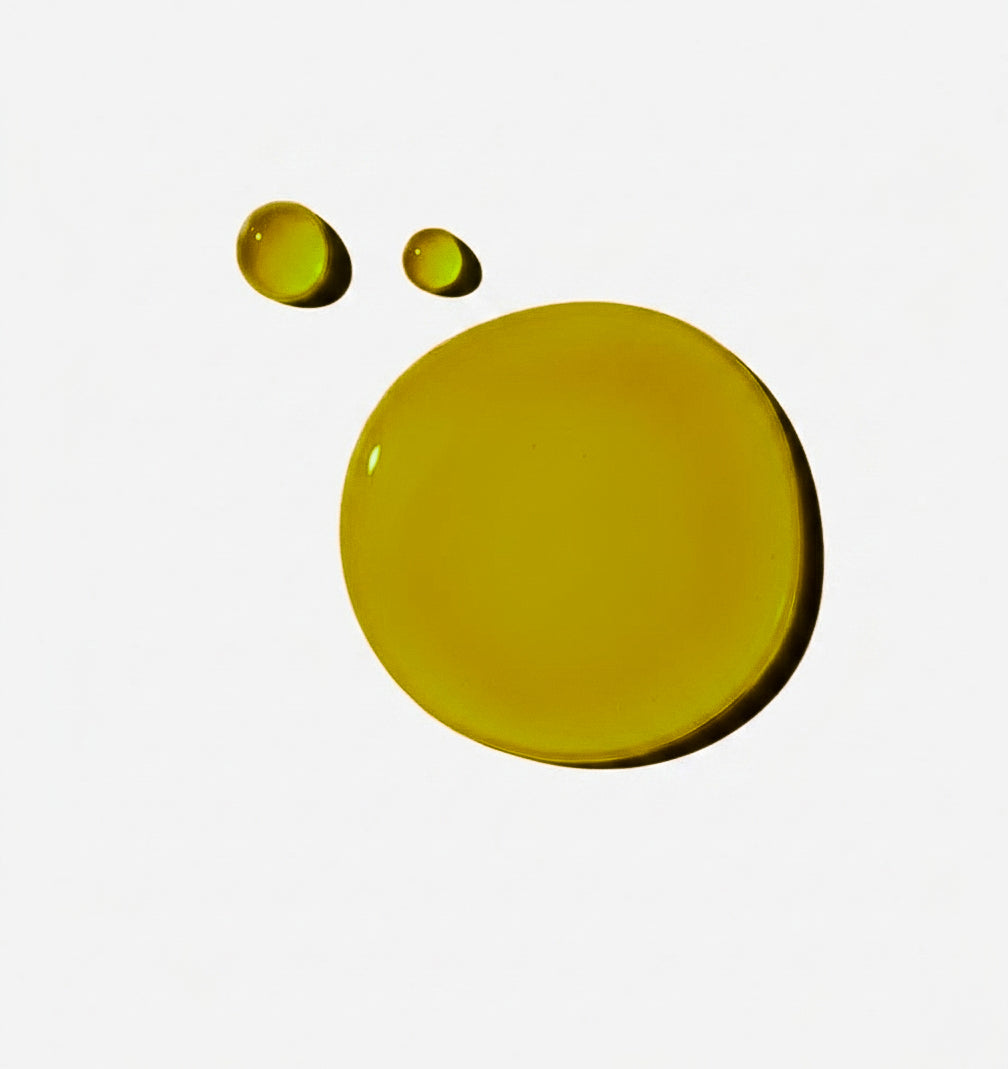 Two green serum droplets on a white background
