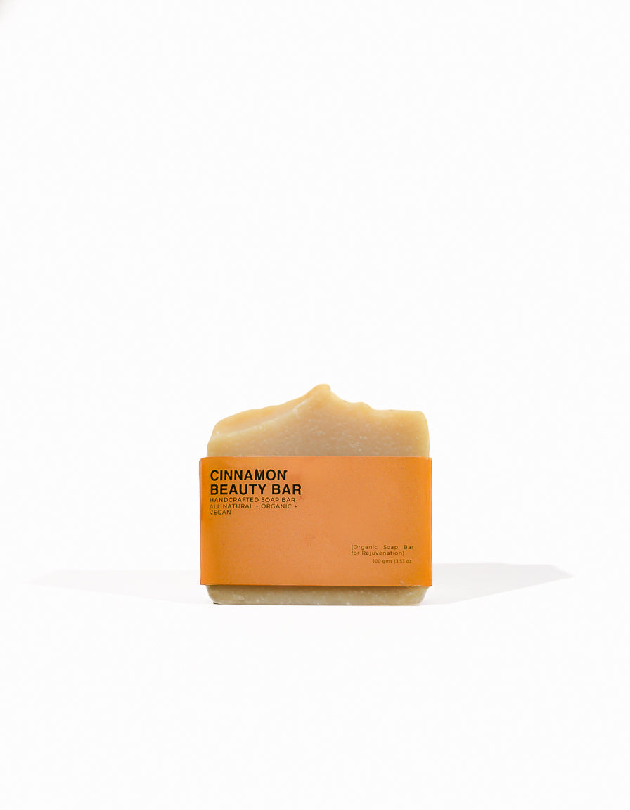 Cinnamon handmade soap bar with orange packaging on a white background