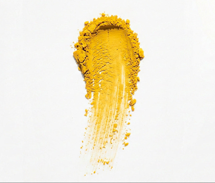 Yellow face mask powder spread on a white background