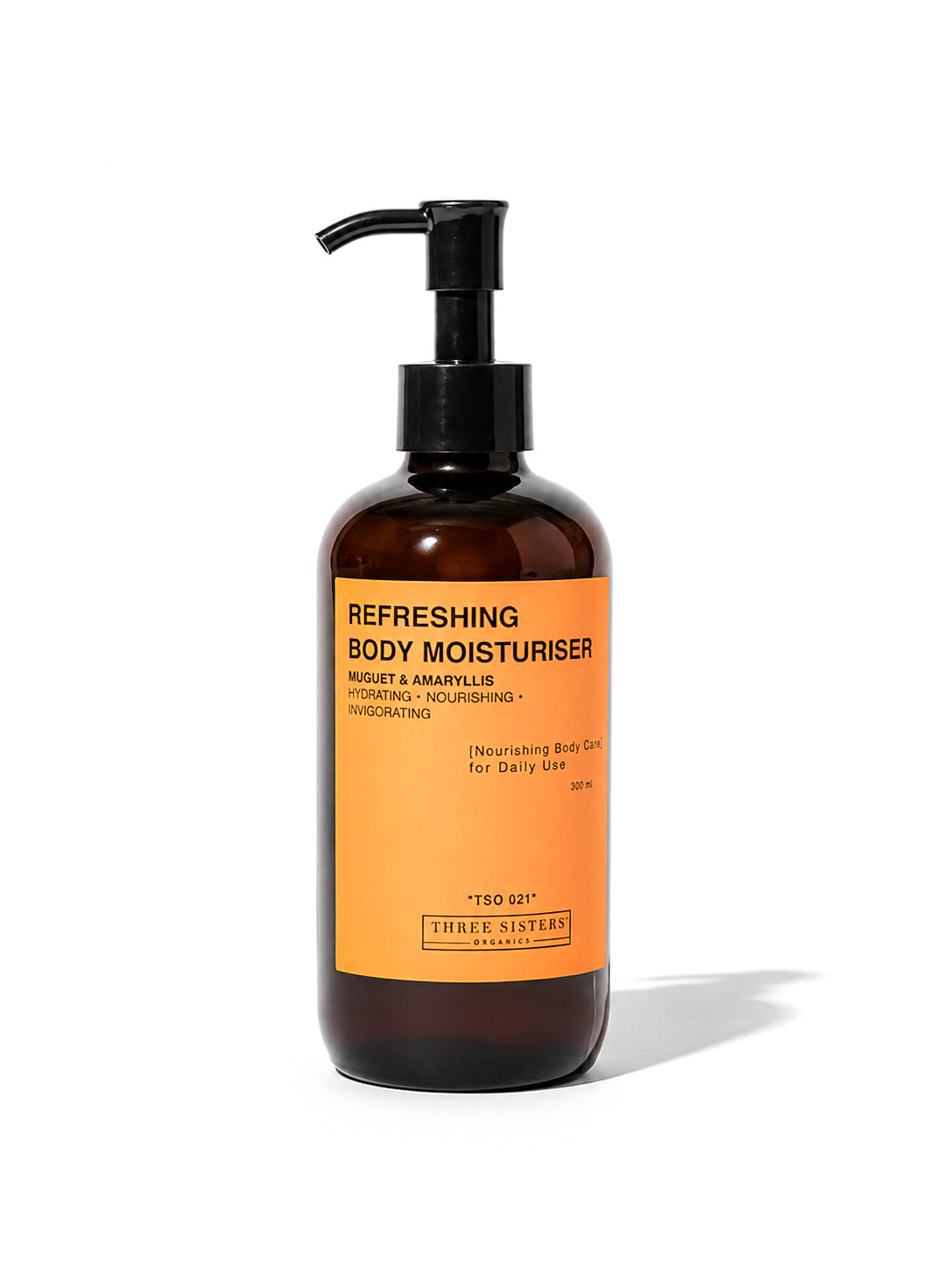 A pump bottle of Three Sisters Organics Refreshing Body Moisturiser, featuring an amber brown bottle and a bright orange label with black text, set against a plain white background.