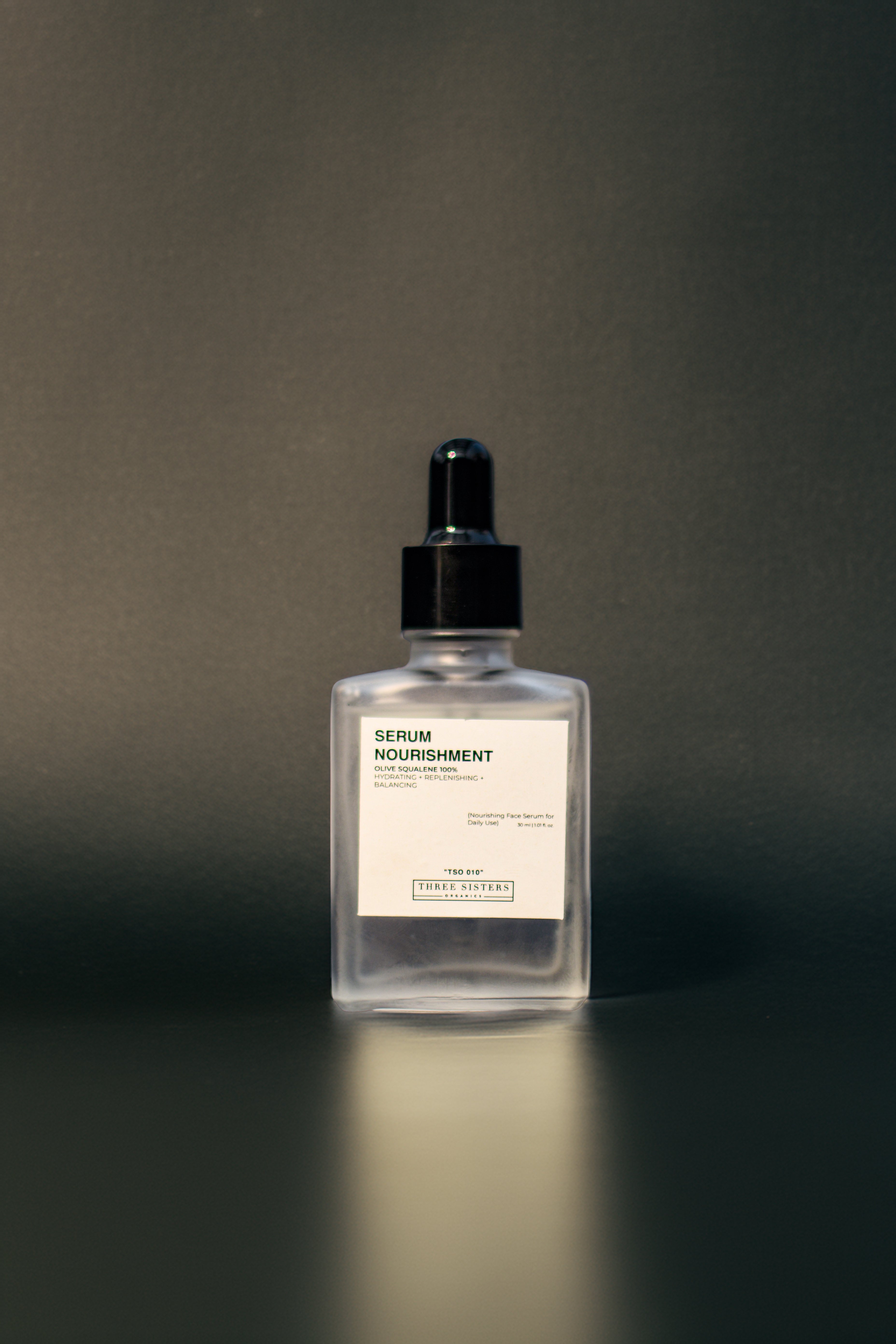 Serum Nourishment, Hydrating Face Serum, square glass dropper bottle, reflective surface, front view