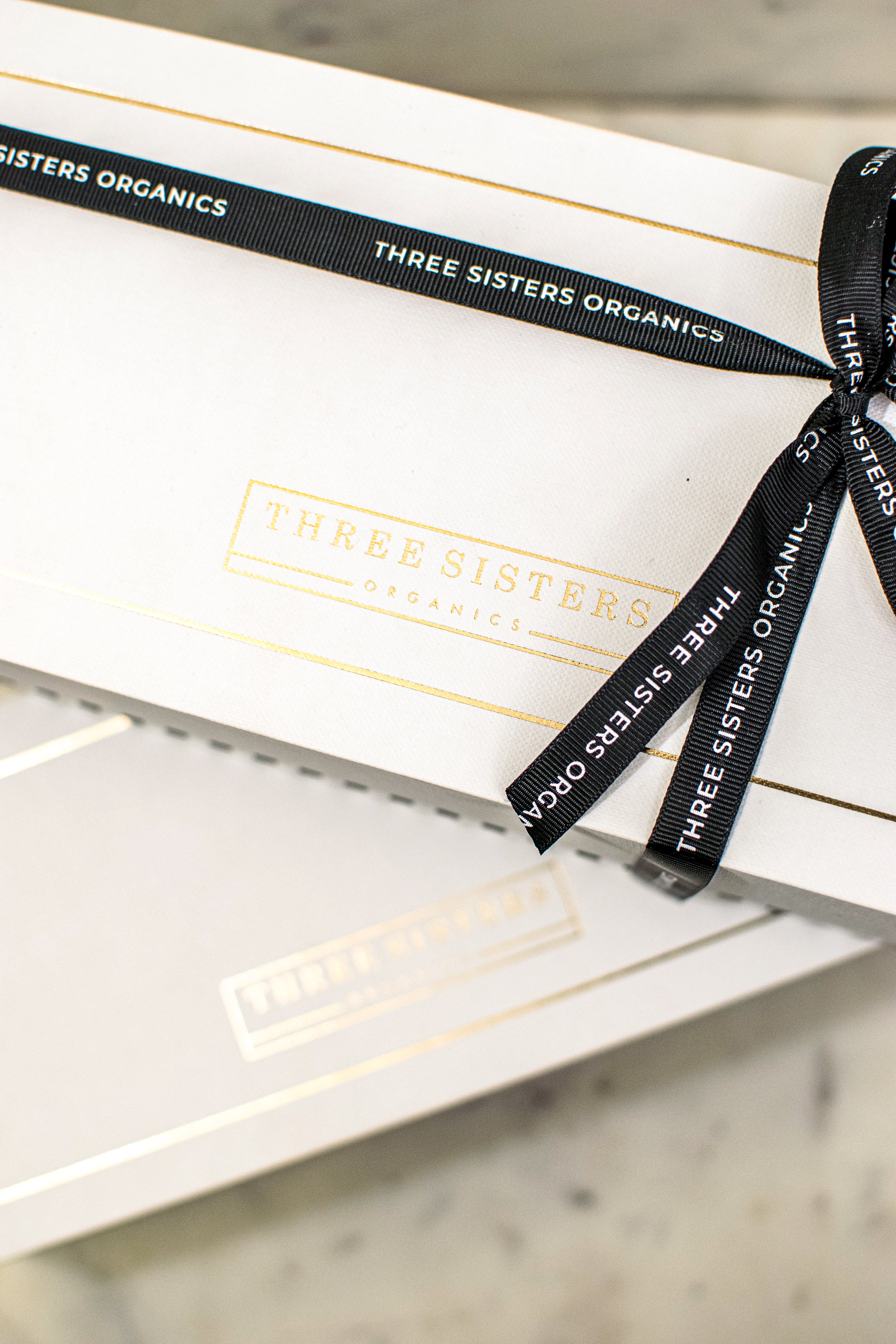 Two white gift boxes with black ribbon