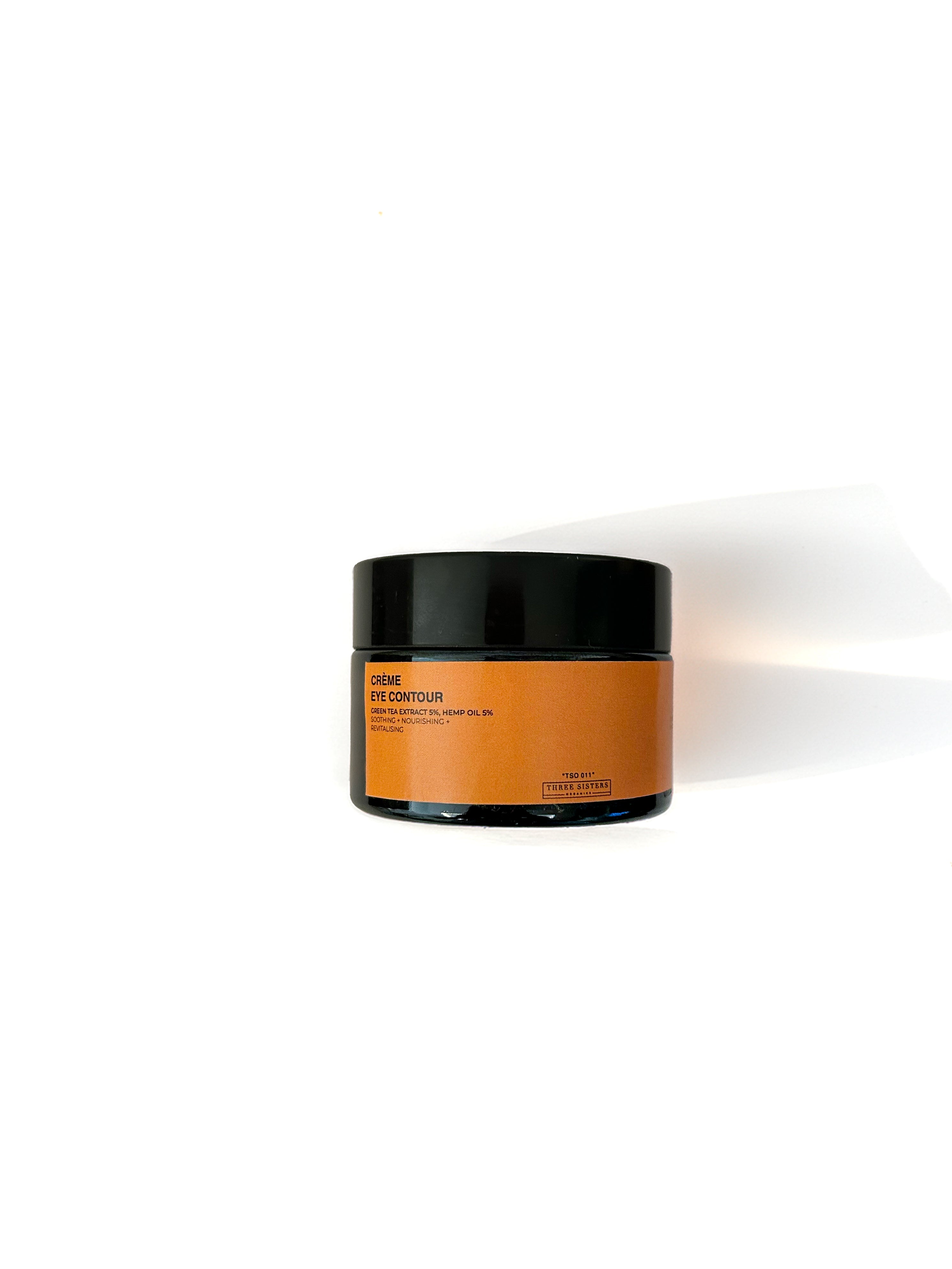 Jar of under eye cream with black lid on a white background