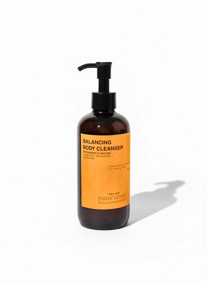 Amber bottle of balancing body cleanser with an orange label on a white background