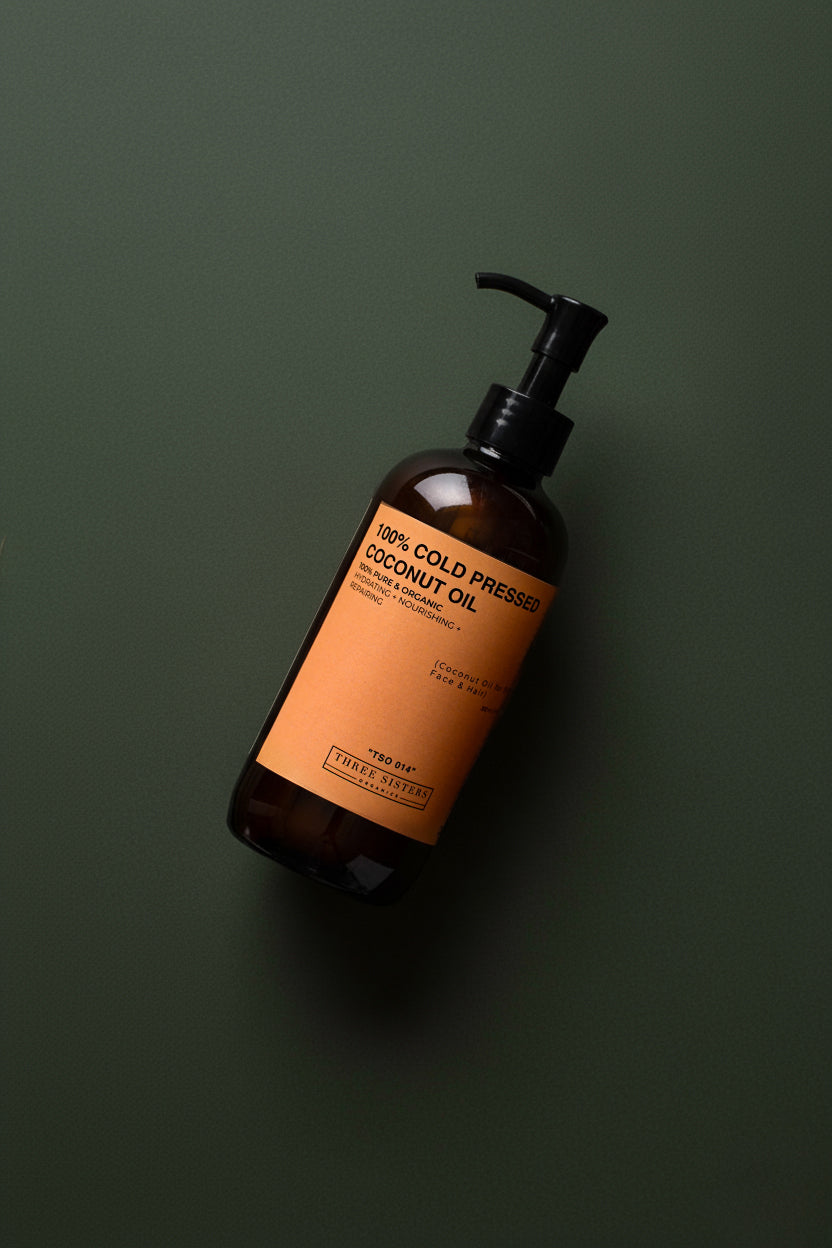 Bottle of 100% Cold Pressed Coconut Oil on a dark green background