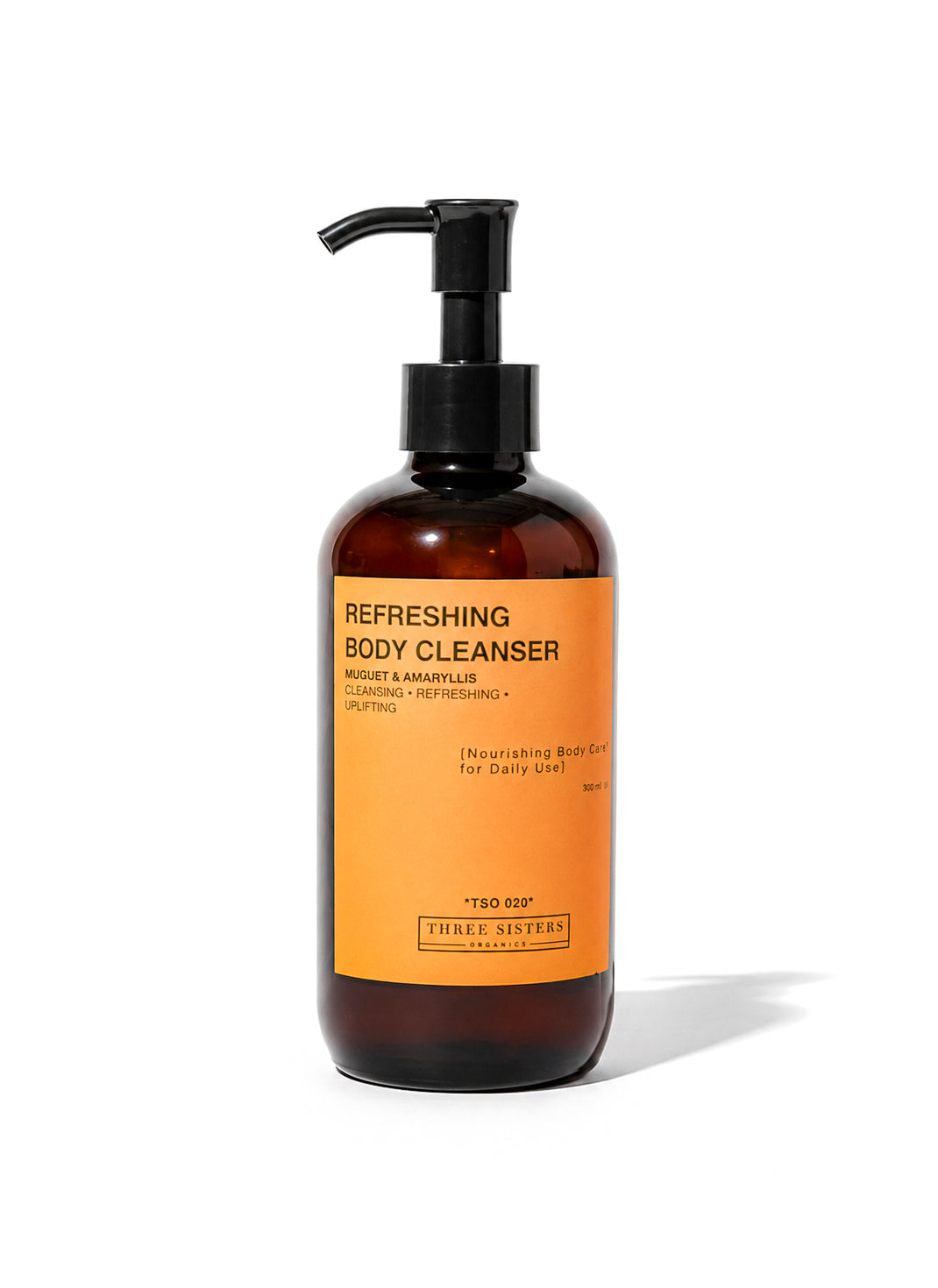 A bottle of Three Sisters Organics Refreshing Body Cleanser with a black pump dispenser and a bright orange label, set against a plain white background.
